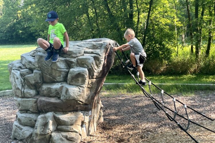 two boys climbing an adventure scapes rock