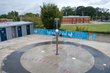 splash pad with water coming out of a baseball bat with a ball on top of it