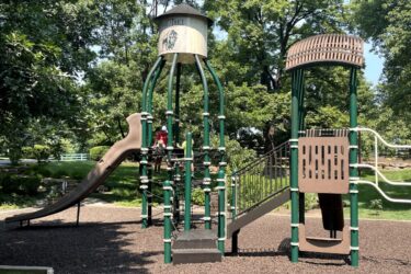 2 kids climbing nets to the top of the slide area