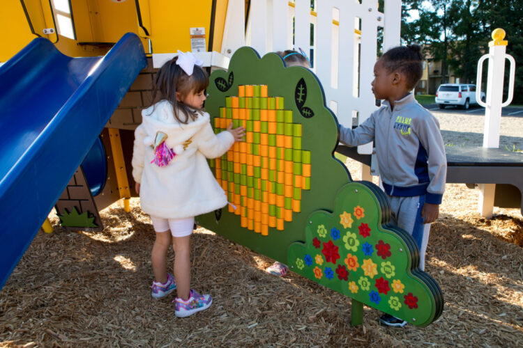 two kids playing on flower display that has rotating pieces used to create designs
