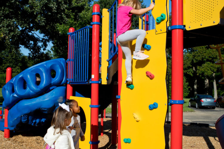 close up of boy almost at the top of the climbing wall