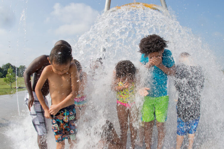 group of kids getting sprayed by water