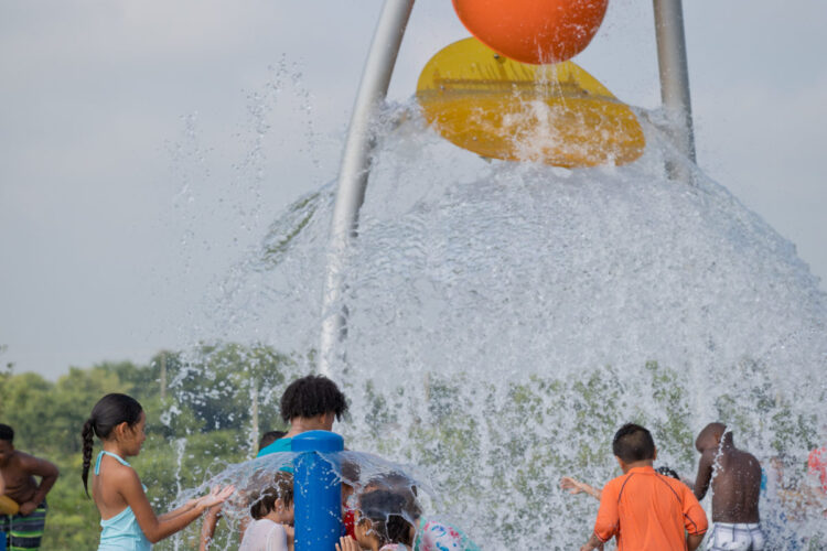 water spraying a wide spray on kids below
