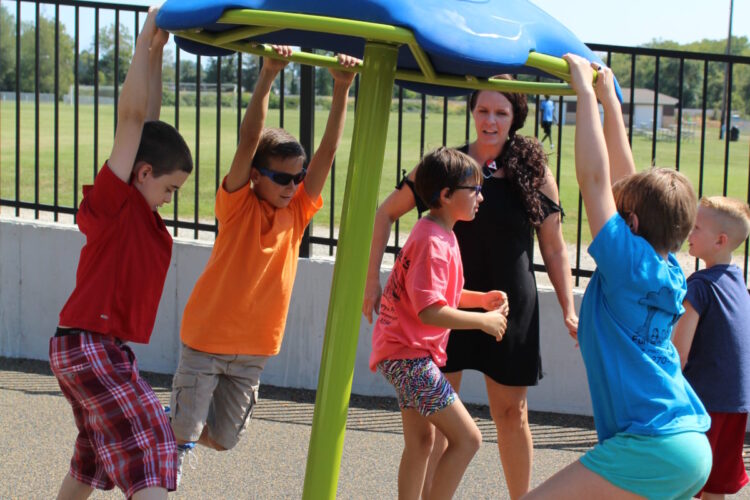 boys and girls hanging from spinning wheel