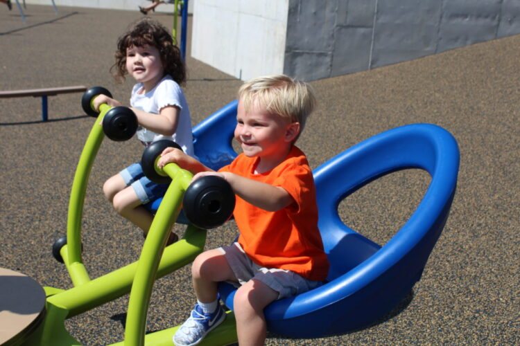 boy and girl close up on blue and green bouncer seats