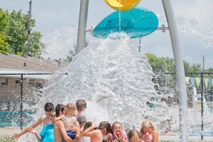 large bucket of water dumping on a bunch of children waiting