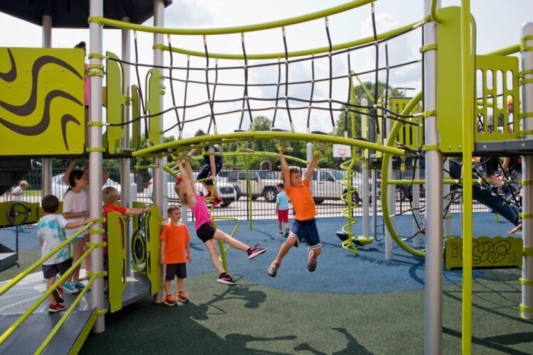 two kids crossing the monkey bars