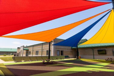 red, orange, blue and yellow shades above courtyard at school
