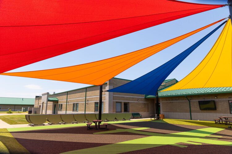 red, orange, blue and yellow shades above courtyard at school