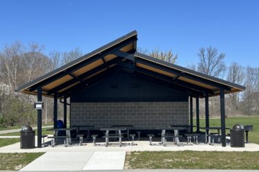 2-tier metal shelter with tongue and groove shelter with trash receptacle and picnic tables