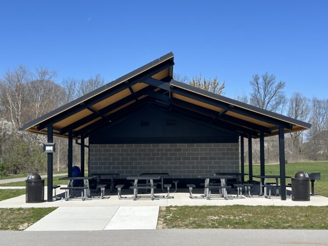 2-tier metal shelter with tongue and groove shelter with trash receptacle and picnic tables
