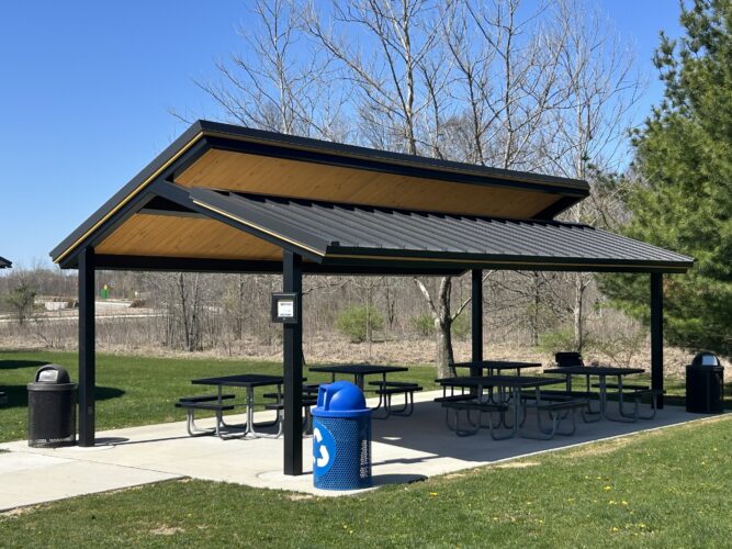2-tier metal shelter with tongue and groove shelter with trash receptacle and picnic tables