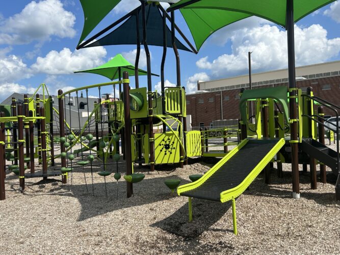 sensory roller slide on play structure with multiple play events and shade
