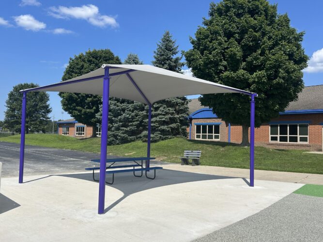 4 post fabric shad structure with blue picnic table underneath