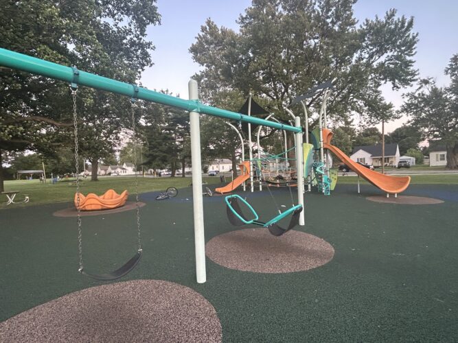 2 swing bays, orange slides, and inclusive spinner