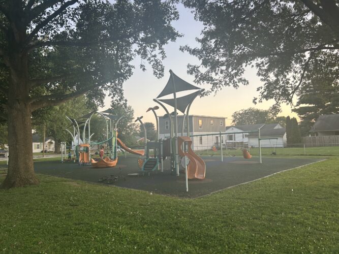 playground with a play structure for 2-5 year olds and a play structure for 5-12 year olds with swings and spinner