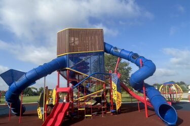 3 level play structure with multiple climbing events and slides
