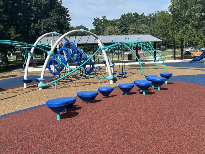 red rubber safety surfacing with round stepping pods and climbers