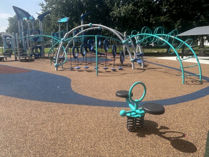 brown and blue rubber surfacing with climbing structures and double bouncy rider