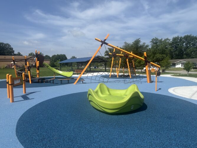climbing play structure with slide and multi-person sit down spinner