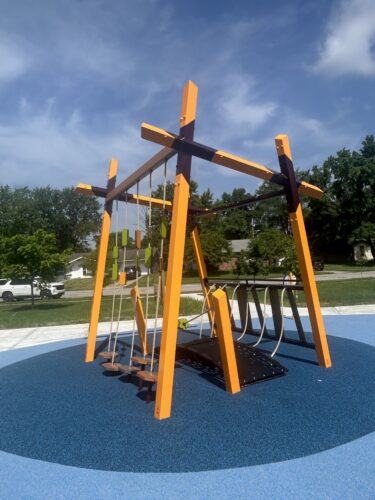 purple, orange, and green climbing features on a play structure