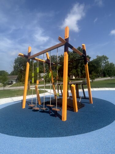 purple, orange, and green climbing features on a play structure