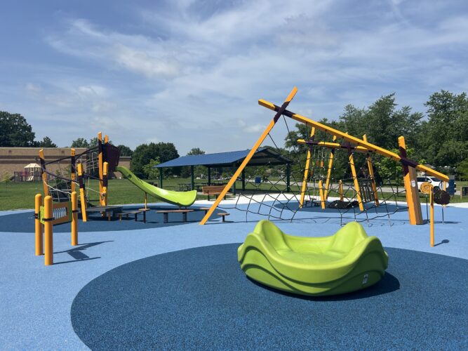 multiple climbing structures, green slide, and zylophone