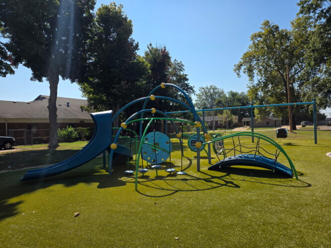 blue, yellow, and green play structure with a slide and bridge for kids ages 2-5