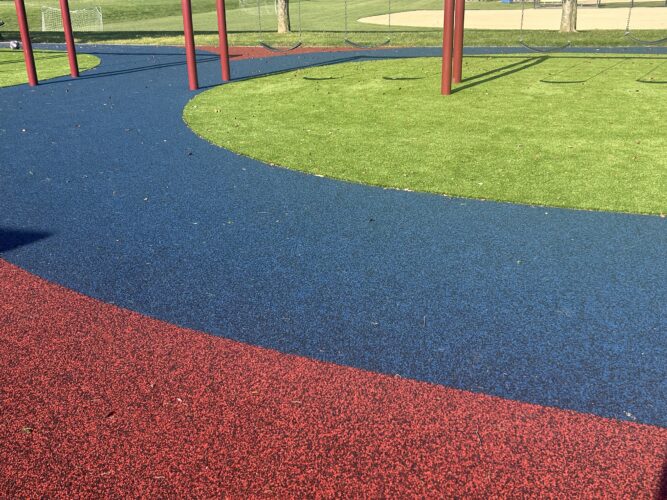 playground surfacing with green turf and red and blue rubber surfacing
