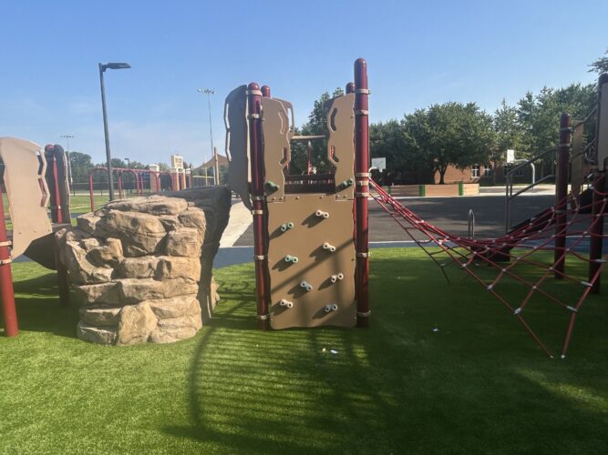 Reinforced fiber glass climbing rock with a climbing wall and climbing net