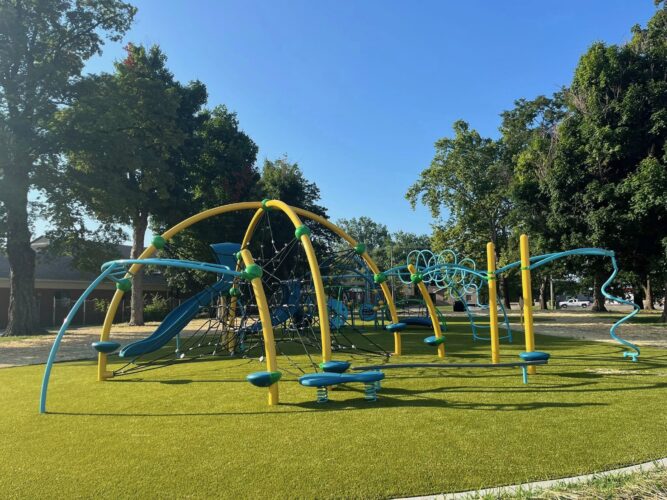 play structure for kids ages 5-12 with climbers, slides, and stepping pods on green turf